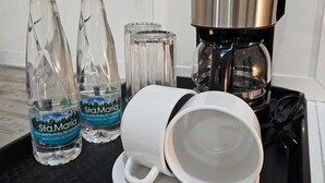 Un plateau avec deux bouteilles d’eau, un verre et une cafetière.