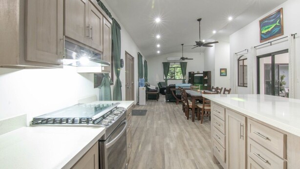 Una cocina moderna con armarios de madera, encimera blanca y horno empotrado.