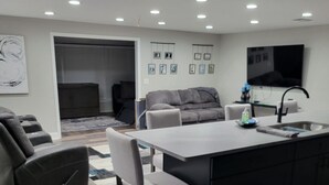 A modern kitchen with a central island, bar stools, and a dining table. - Snow Bird Alert -3 Month Rental - Venice Isle Estates -2 Bed 2 Bath House  (Venice)