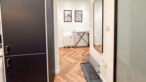 Eine moderne Wohnung mit einem dunklen Kleiderschrank, einem Spiegel und zwei gerahmten Kunstwerken an der Wand.