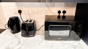 Eine Küche mit Arbeitsplatte, Toaster, Wasserkocher und Mikrowelle.