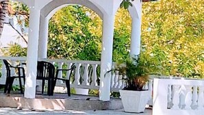 An outdoor seating area with white arches and potted plants. - Turquoise Sea Villa (Montego Bay)