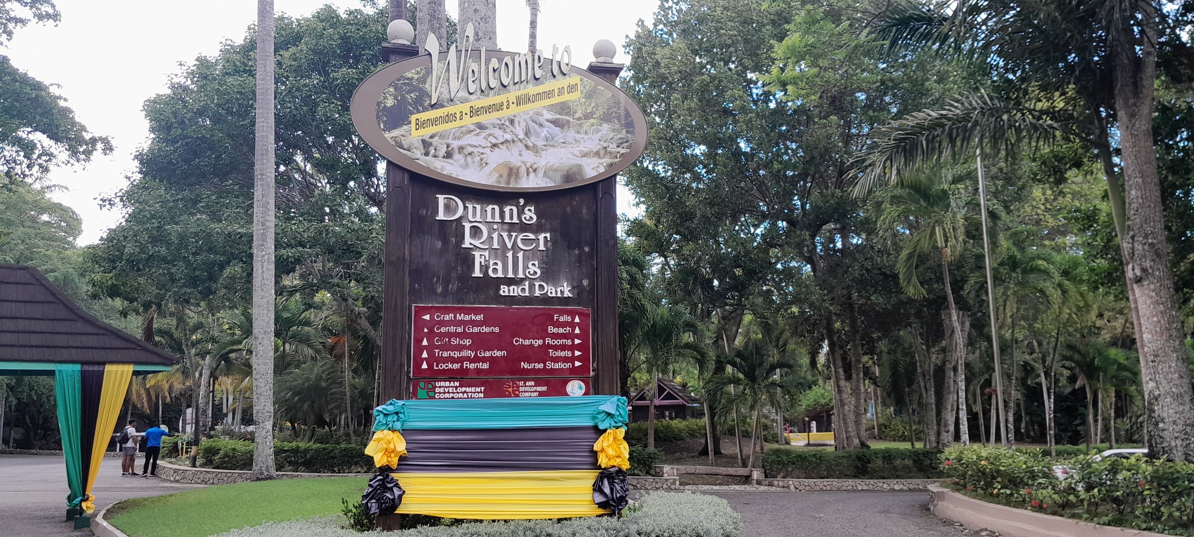 Señal de Dunn's River Falls and Park con indicaciones hacia varios servicios como el Mercado de Artesanías, los Jardines Centrales y la Tienda de Regalos.