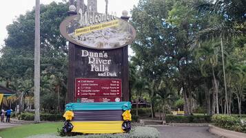 Señal de Dunn's River Falls and Park con indicaciones hacia varios servicios como el Mercado de Artesanías, los Jardines Centrales y la Tienda de Regalos.