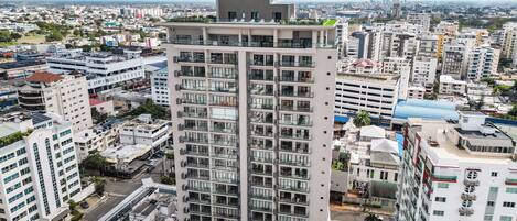 A high-rise building with a prominent 'Aston' sign on top, surrounded by other residential buildings.