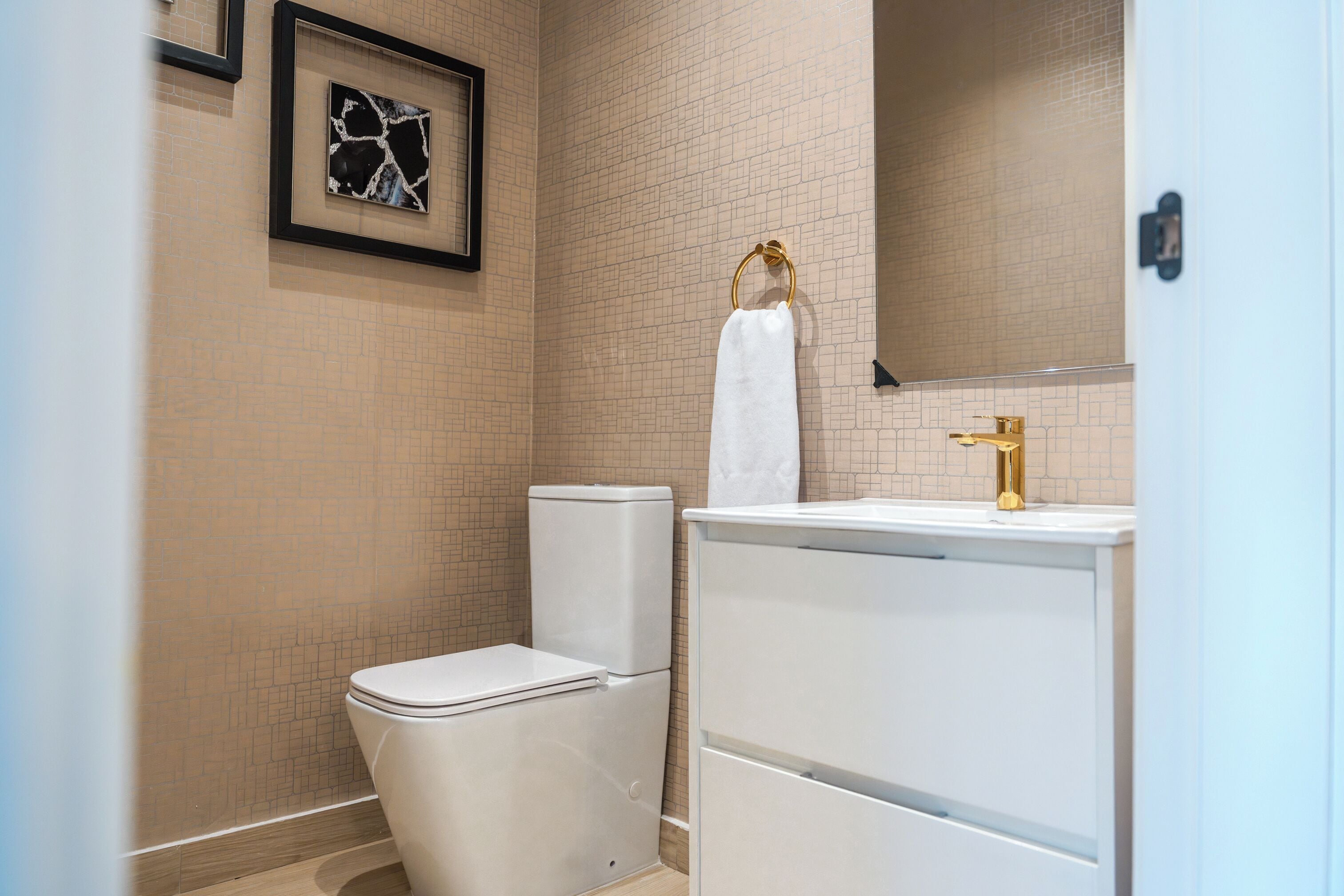 A bathroom with a toilet, sink, and mirror.