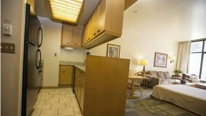 A compact hotel room with a kitchenette, a sofa, a bed, and a window with curtains. - Prime ski week studio in enchanting Snowbird (snowbird)