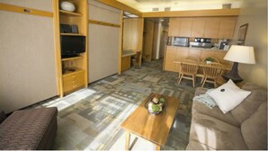 A compact living space with a sofa, a coffee table, a TV, and a kitchenette. - Prime ski week studio in enchanting Snowbird (snowbird)
