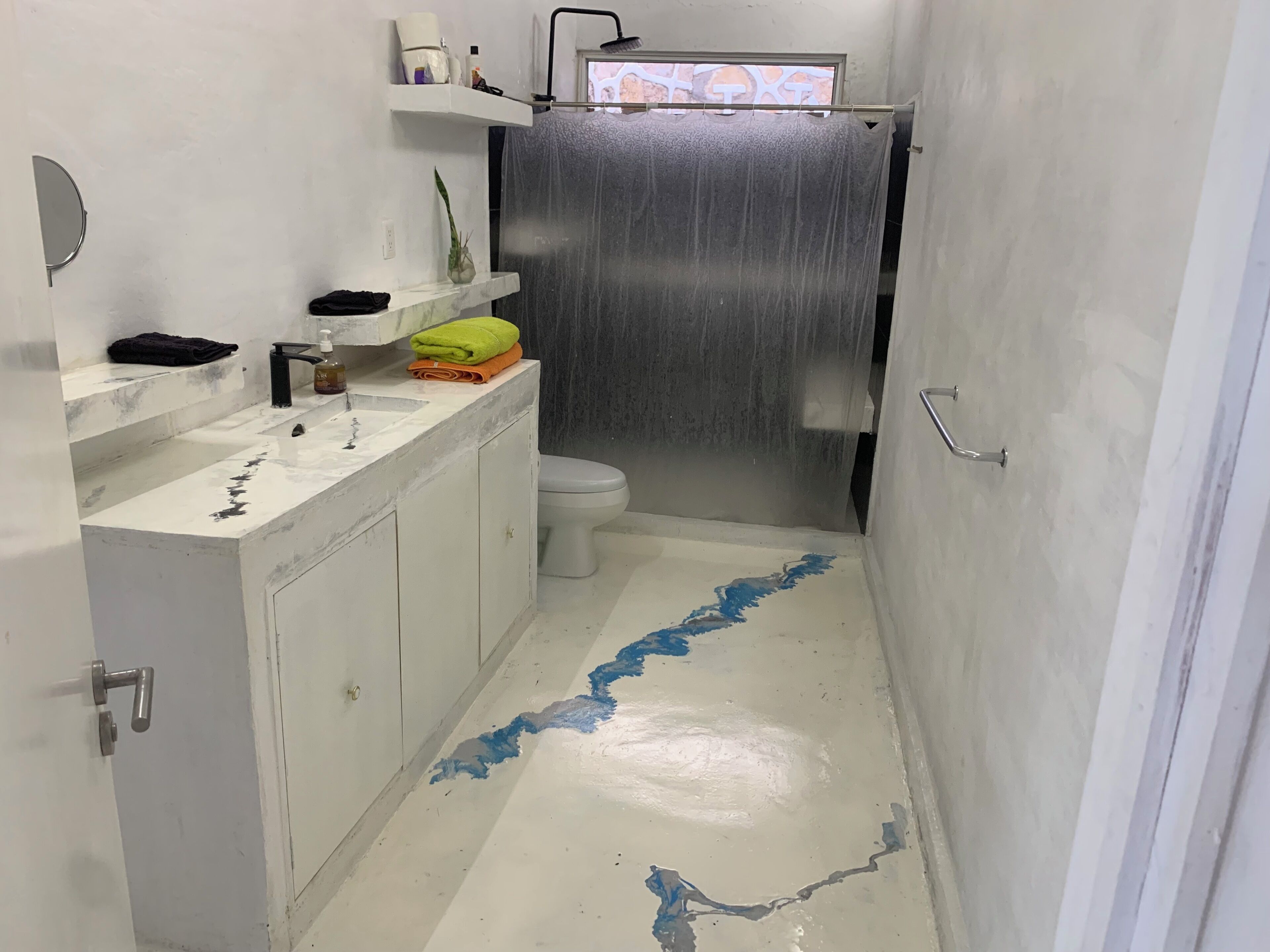 Um banheiro pequeno com pia branca, vaso sanitário e cortina de chuveiro.