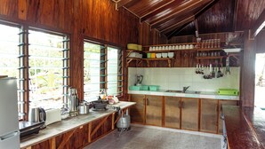 Una cocina con armarios de madera, una encimera y un ventanal con persianas.