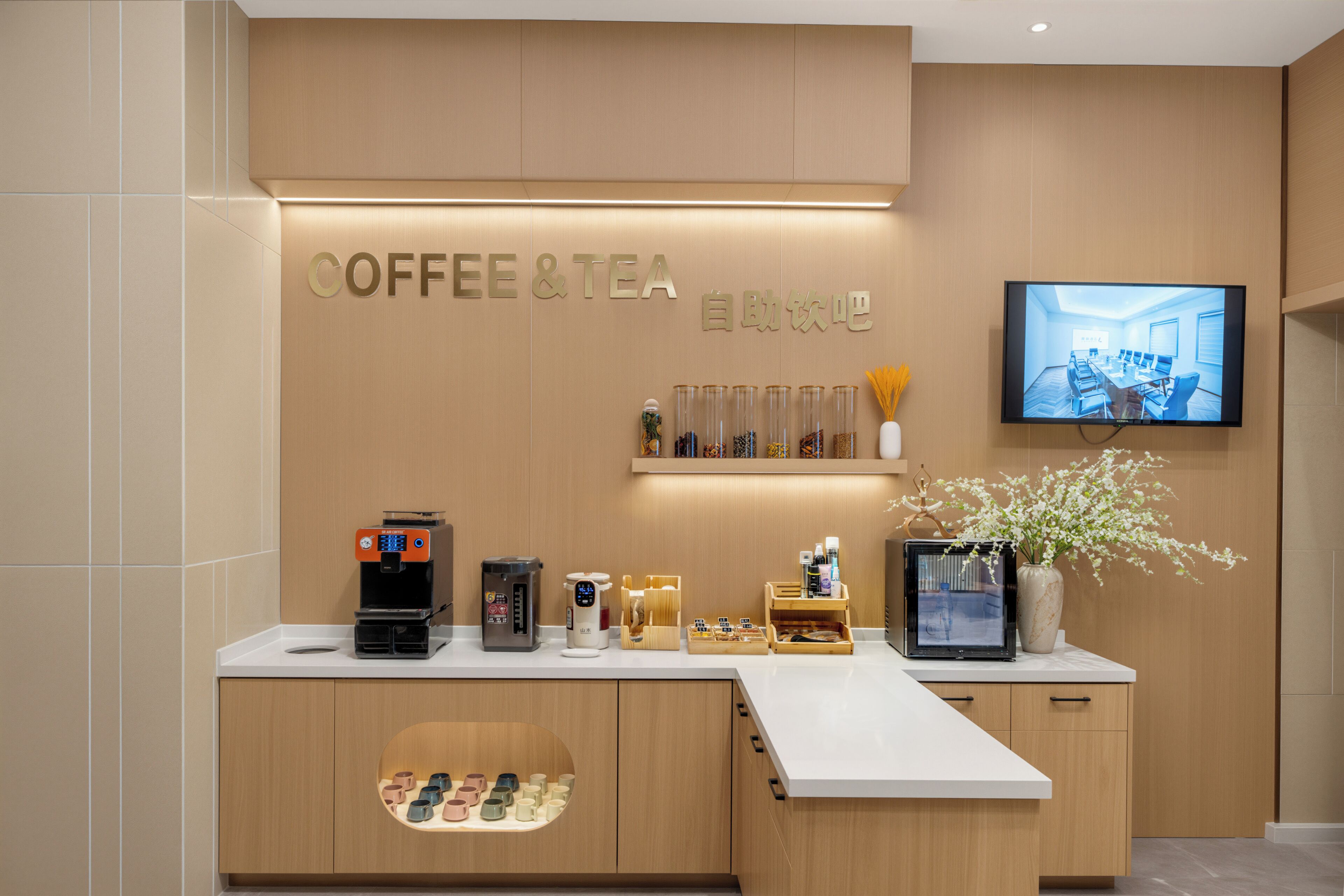 Estación de café y té con cafetera, dispensador de té y diferentes bolsitas de té.