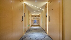 A long, narrow hotel corridor with wooden walls and a patterned carpet. - Lavande Hotel Xi'an Bell Tower Muslim Street North Street Subway (Xi'an)