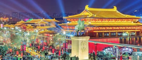 Un edificio chino tradicional con arquitectura ornamentada y una estatua de una figura a caballo.