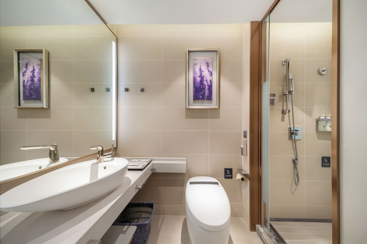 Un baño moderno con un lavamanos grande, inodoro y ducha.