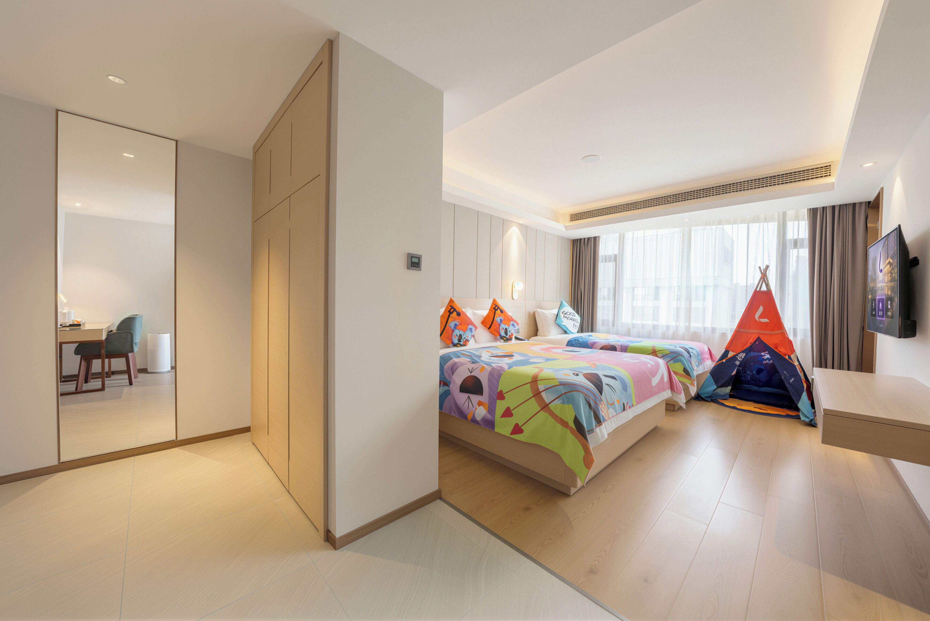 Una habitación de hotel con cama, escritorio, silla, armario y ventana.