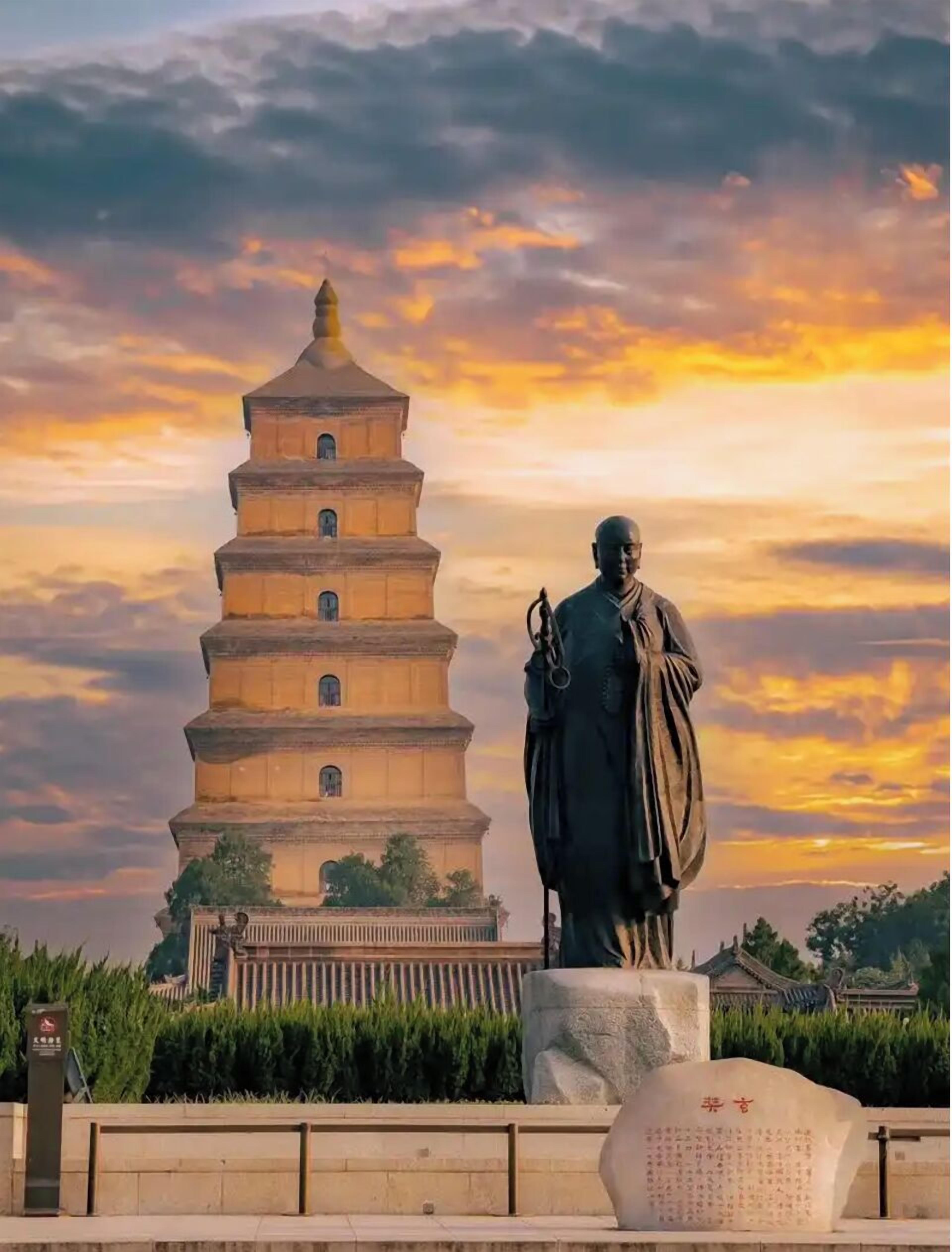 Una torre de estilo pagoda con una estatua al frente.