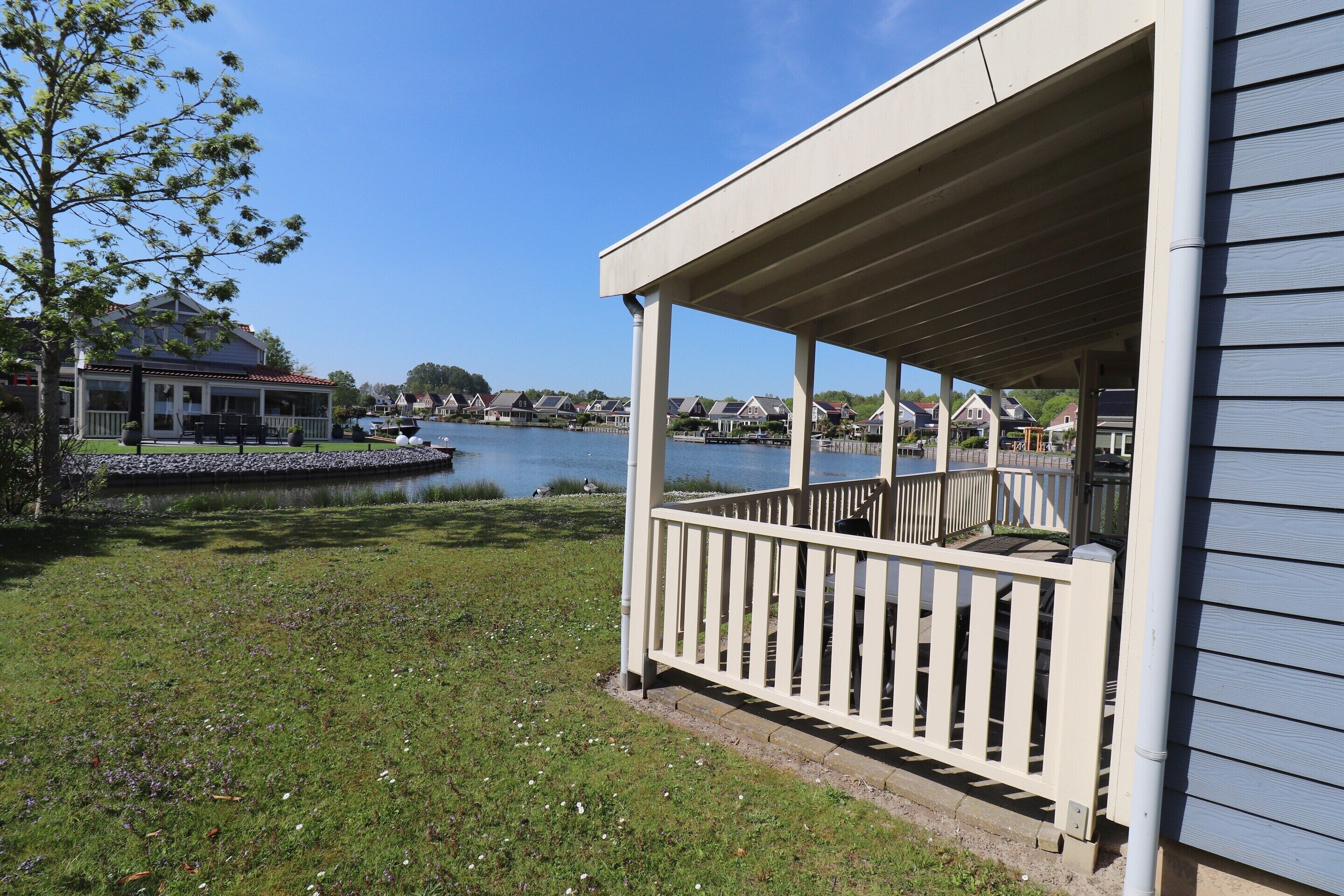 Una proprietà sul lungolago con un portico coperto, un prato e vista lago.
