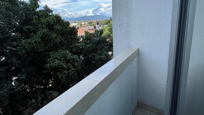 Un balcón con vista a árboles y edificios lejanos.