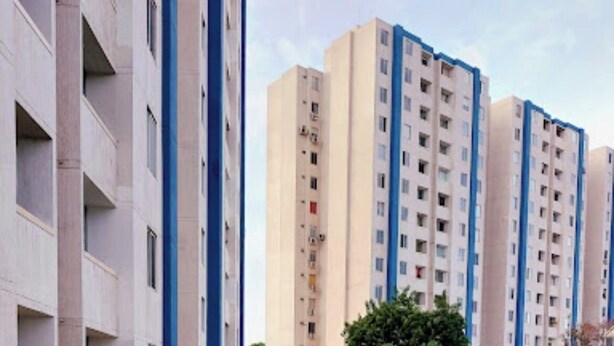 Un camino que lleva a un complejo residencial de varios pisos con balcones.
