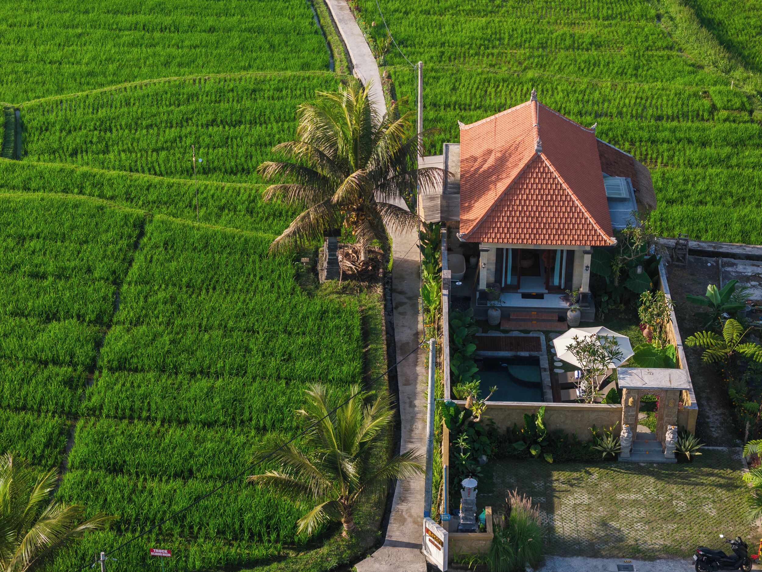 A house with a tiled roof, surrounded by lush green fields.