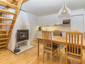 Een moderne keuken met witte kastjes, een inbouwoven en een hanglamp.