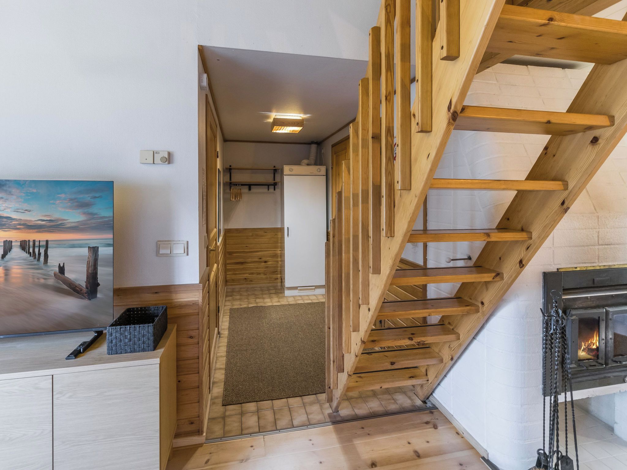 Un escalier en bois mène à une chambre située en mezzanine, d’où l’on peut admirer le ciel.