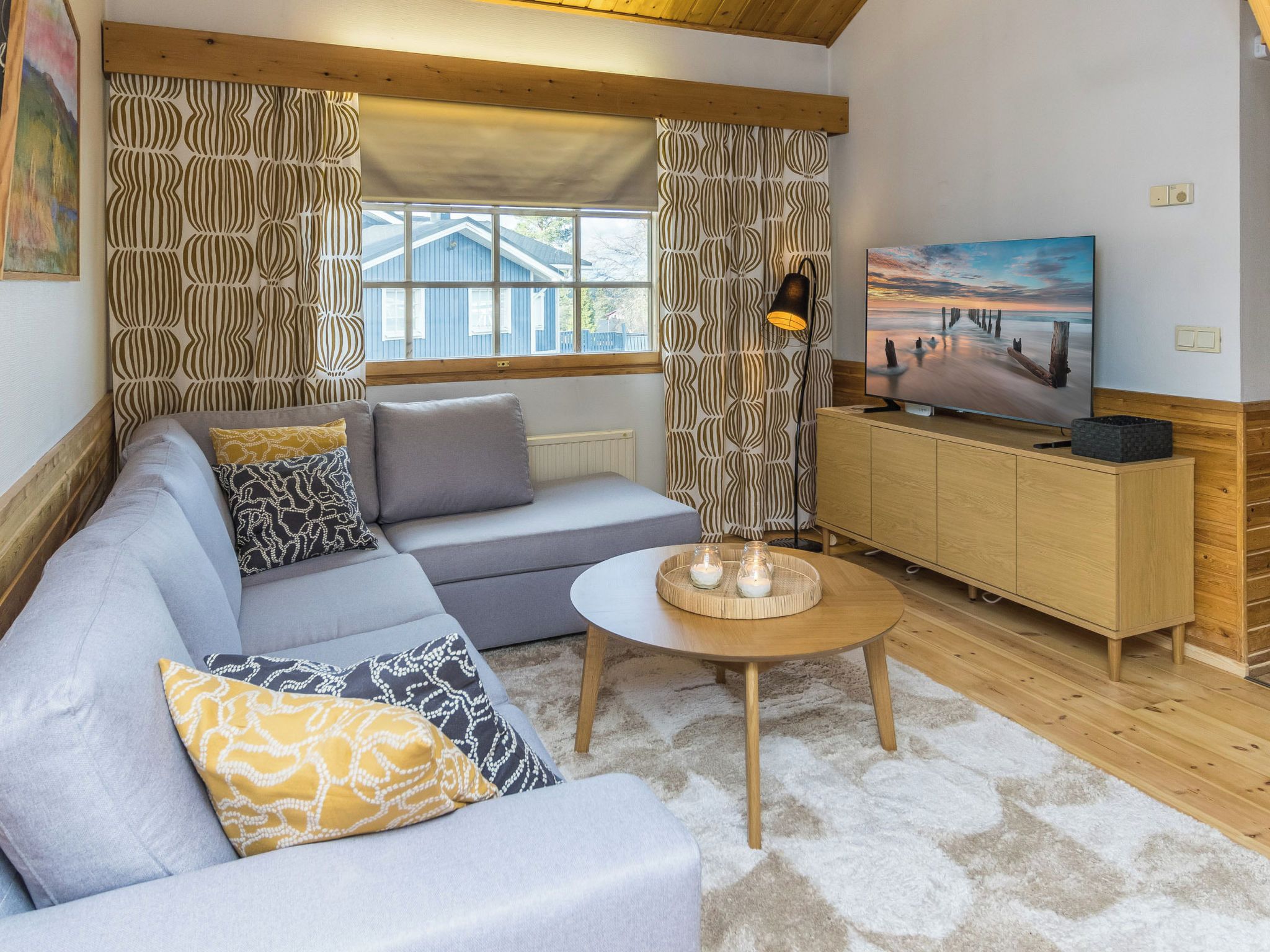 A living room with a sofa, a coffee table, and a TV on a wooden cabinet.