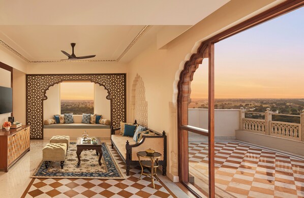 A balcony with a checkered floor, a sofa with cushions, a small table, and a decorative screen. - Anantara Jewel Bagh Jaipur (Jaipur)