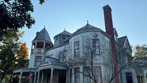 Ein großes, historisches Haus mit mehreren Türmen und einem markanten Schornstein.