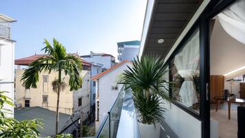 Enjoy the city view from this building's balcony, featuring a railing and potted plants.