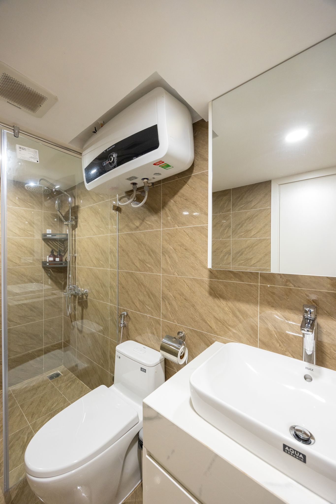 A modern bathroom with a glass-enclosed shower, a white toilet, and a white sink with a mirror above.