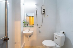 A bathroom with a white sink, toilet, and shower.