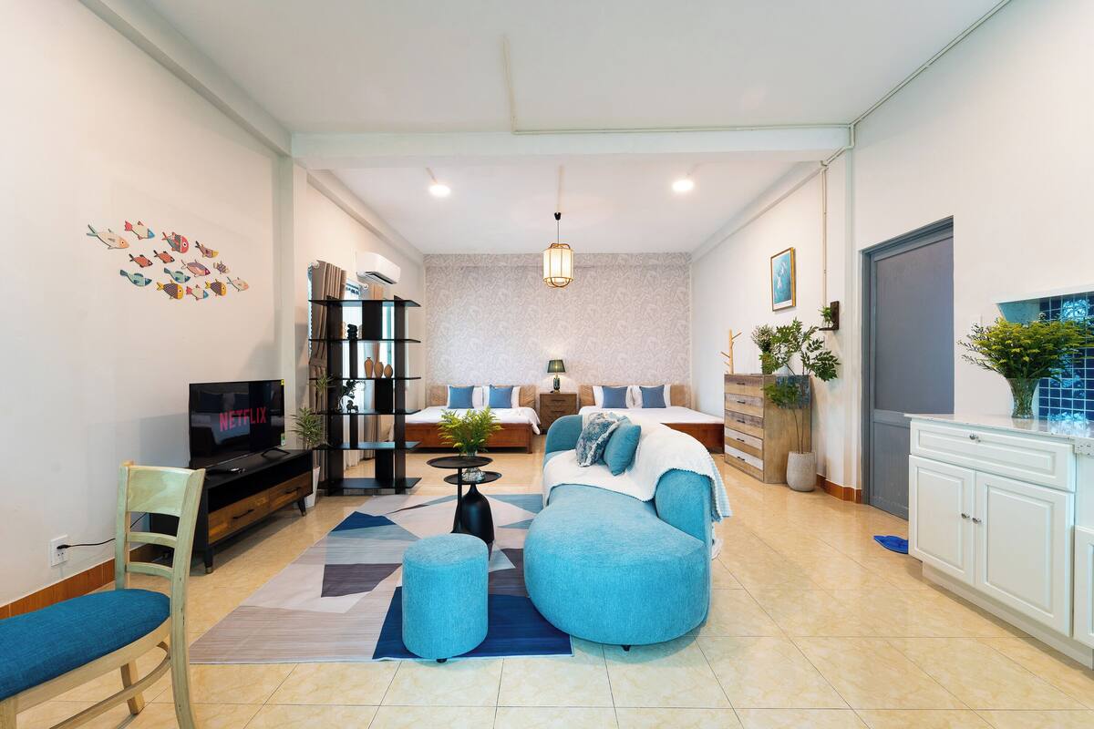 A modern living room with a sofa, TV, and a bookshelf.