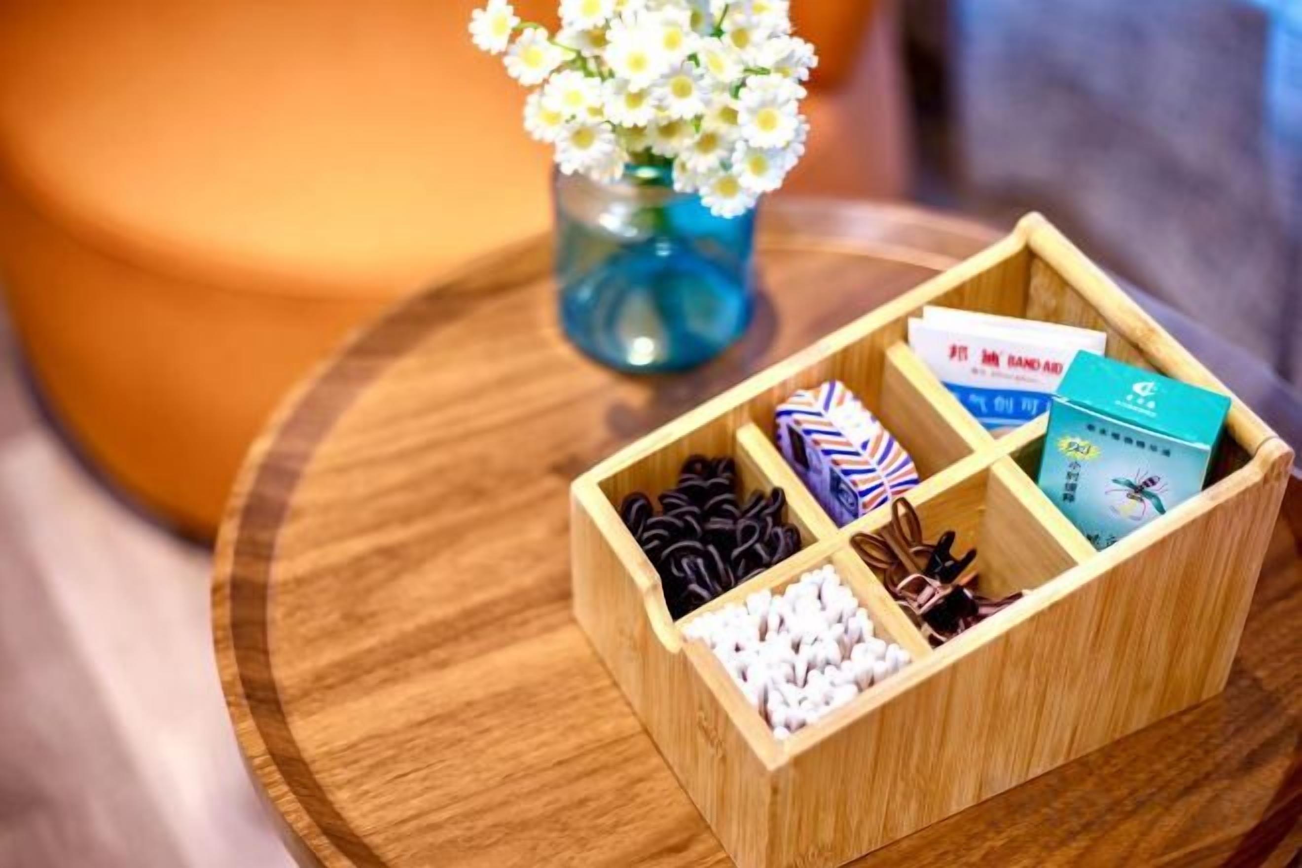 A wooden box with compartments containing various items like cookies, a tie, and cards.