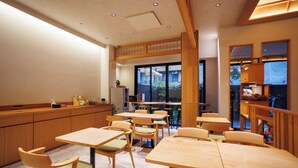 A modern classroom with wooden furniture, a large window, and a ceiling with recessed lighting.