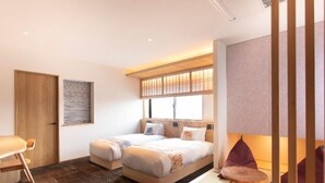 A modern hotel room with a large bed, a desk, and a chair.