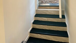 Un escalier menant à une porte donnant sur un jardin.