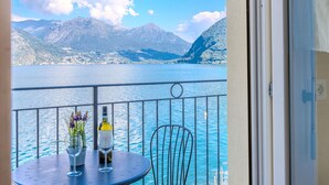 A balcony with a table, two wine glasses, and a bottle of wine. - Cosy apartment for 4 people with WIFI, TV and balcony (Osteno)