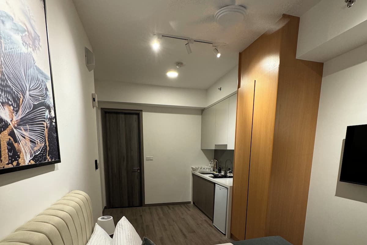 Ein Hotelzimmer mit Bett, einer Couch, einem Schreibtisch, einem Fernseher und einem Badezimmer.