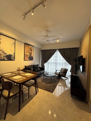 Relax in this stylish living space with a dining area, featuring a sofa, coffee table, and dining table set for a meal.