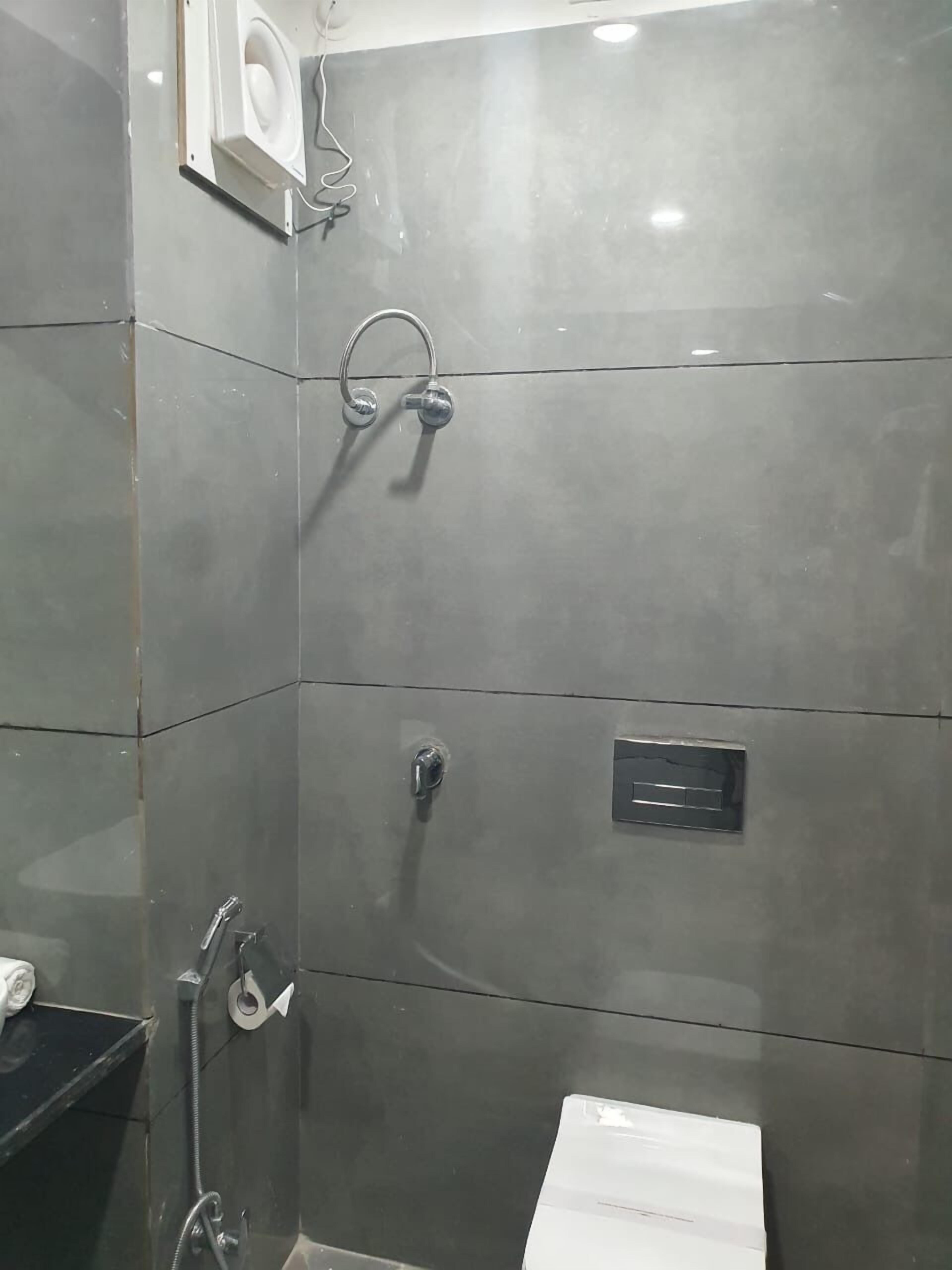 A bathroom with a shower, toilet, and sink.