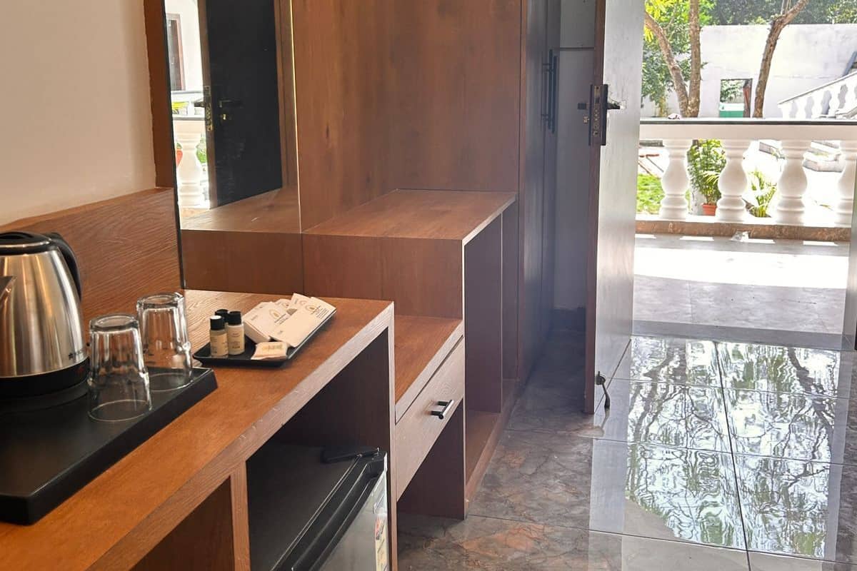 A compact kitchen with a wooden countertop, a coffee maker, and a refrigerator.