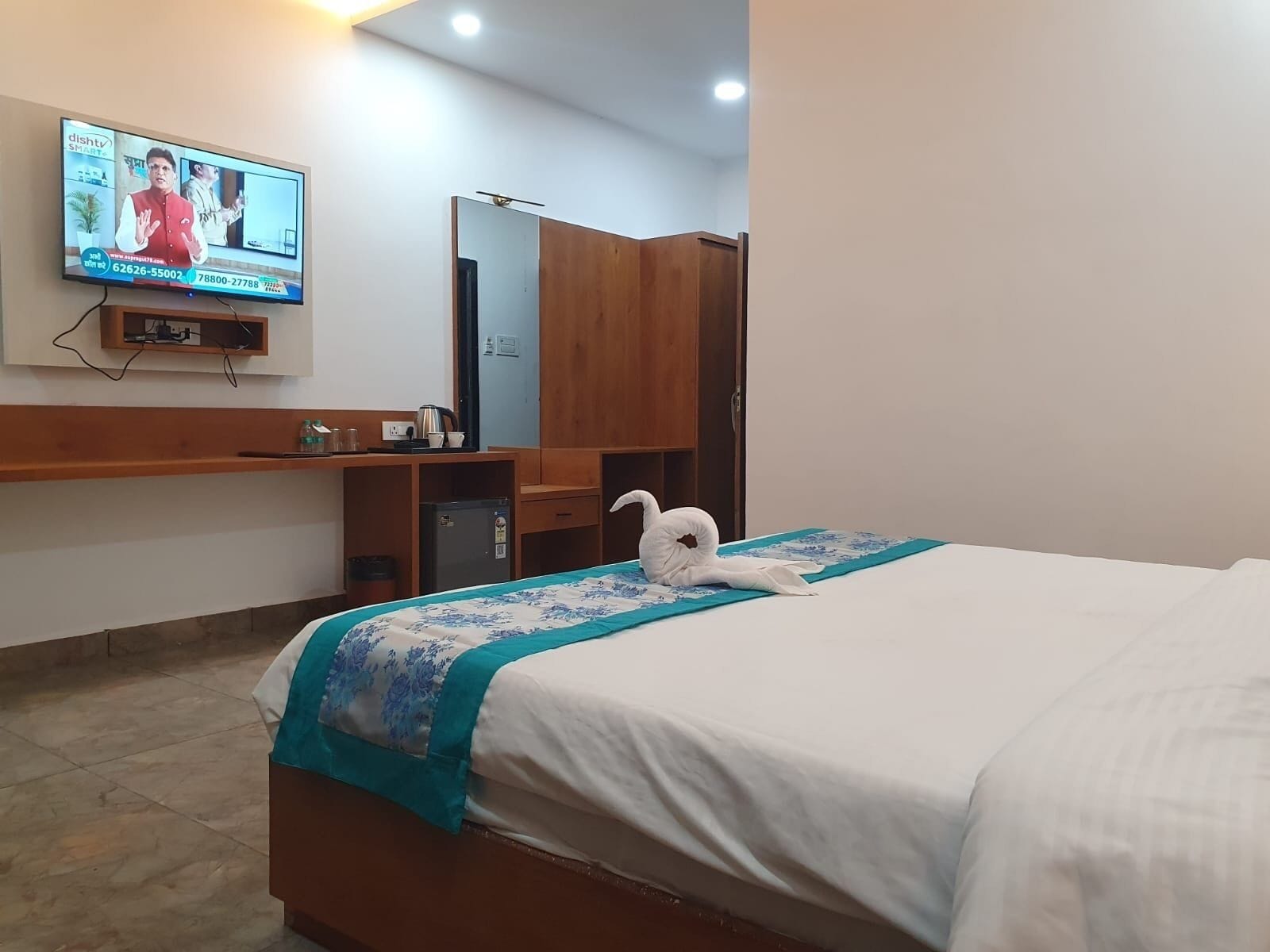 Ein Hotelzimmer mit Bett, Schreibtisch, Fernseher und Kleiderschrank.