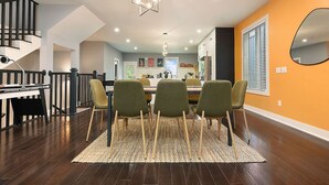 Un coin repas moderne avec une table en bois, quatre chaises et un tapis tissé.