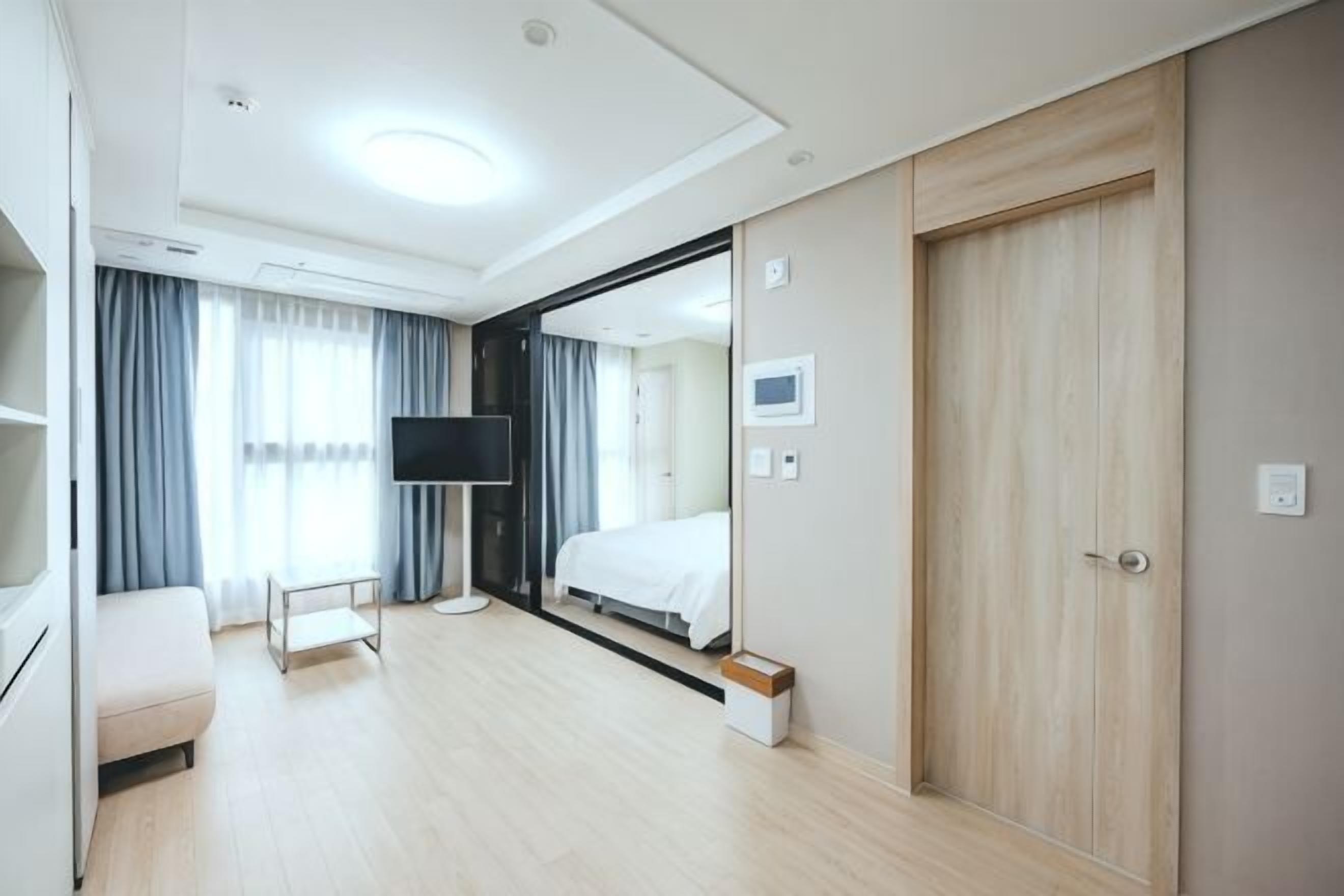 Une chambre d’hôtel avec un lit, une télévision, un bureau et un miroir.