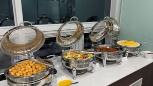 Een buffet met diverse gerechten en een raam op de achtergrond.