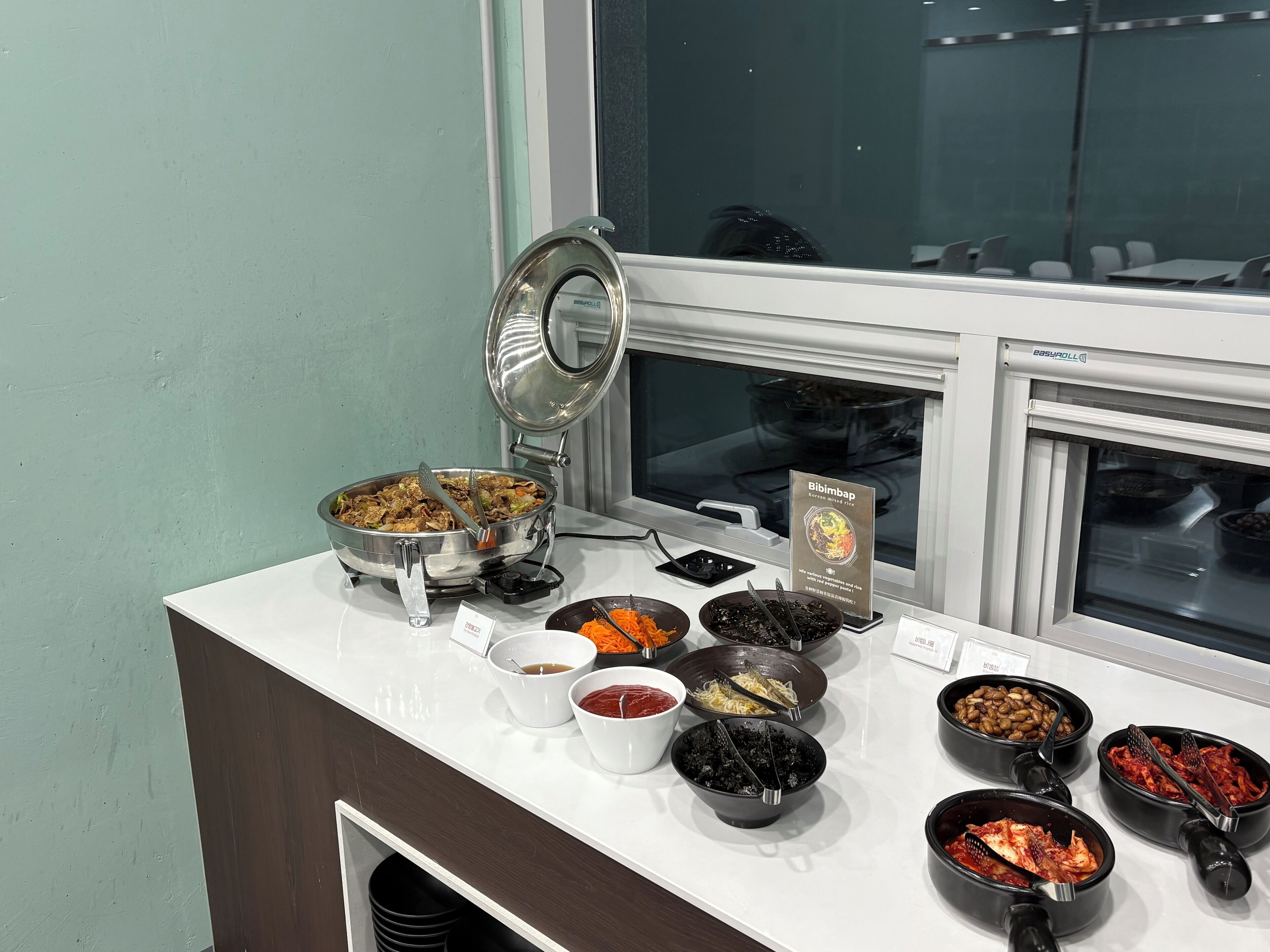 Una barra de buffet con diversos platos y acompañamientos.