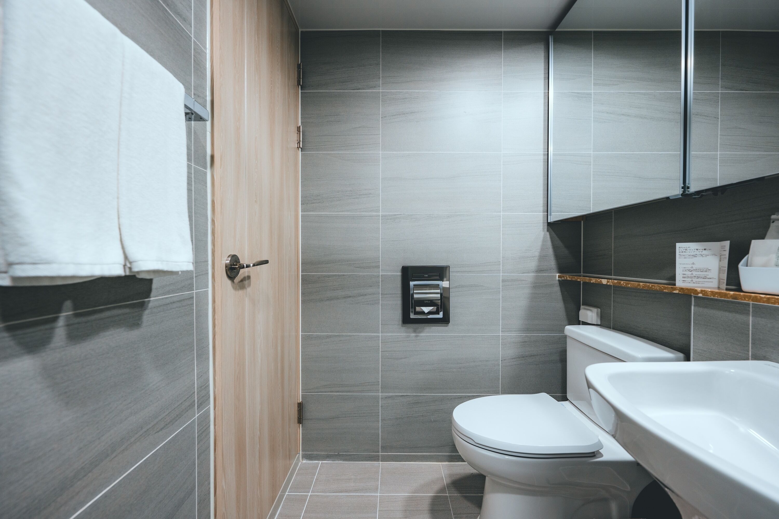 A modern bathroom with a toilet, sink, and towel rack.