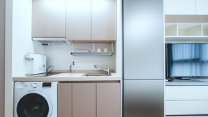 Een moderne keuken met roestvrijstalen apparatuur, een ingebouwde wasmachine en een groot raam.