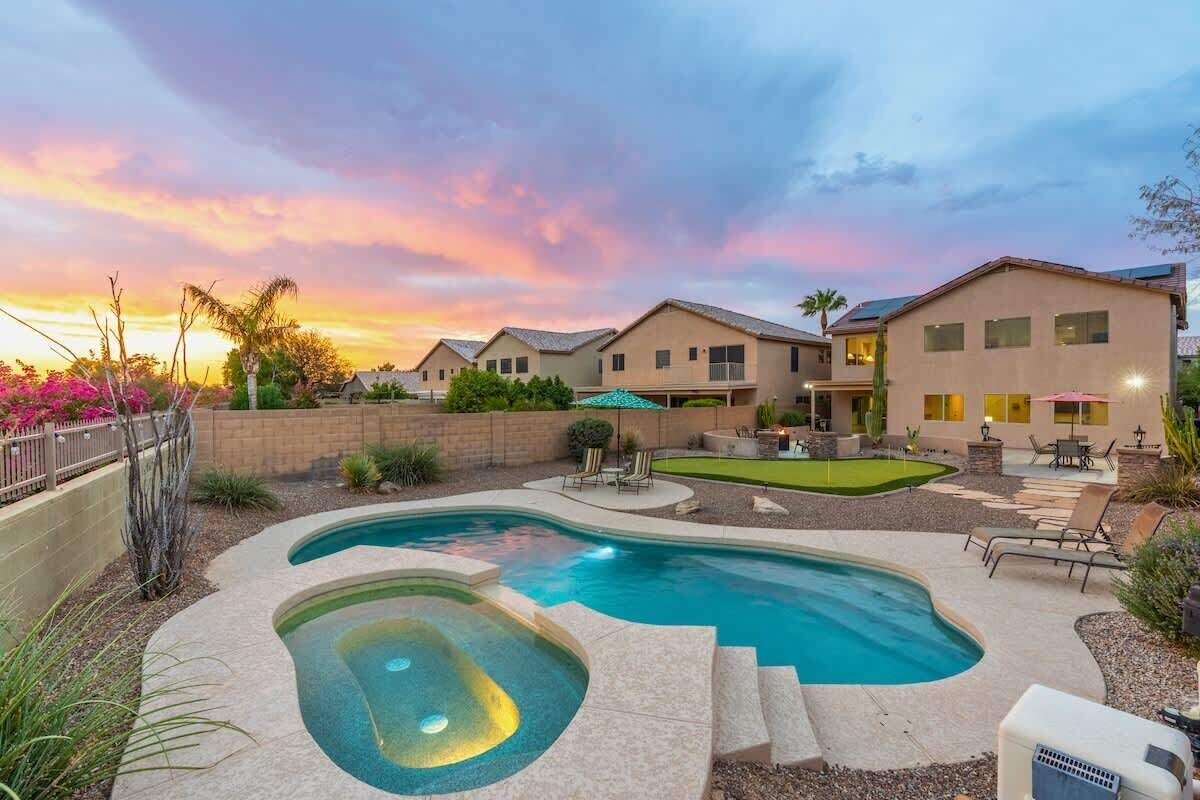 A residential area with a swimming pool, outdoor seating, and a well-maintained garden.